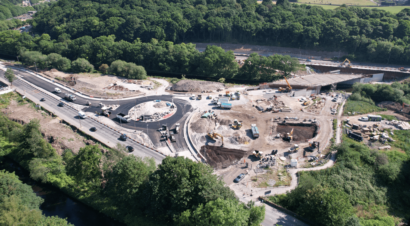 Birds eye view of the new roundabout junction under construction as part of the phase 1b project. The junction is in a half built state with construction vehicles clearly visible in the area alongside Stainland Road. 