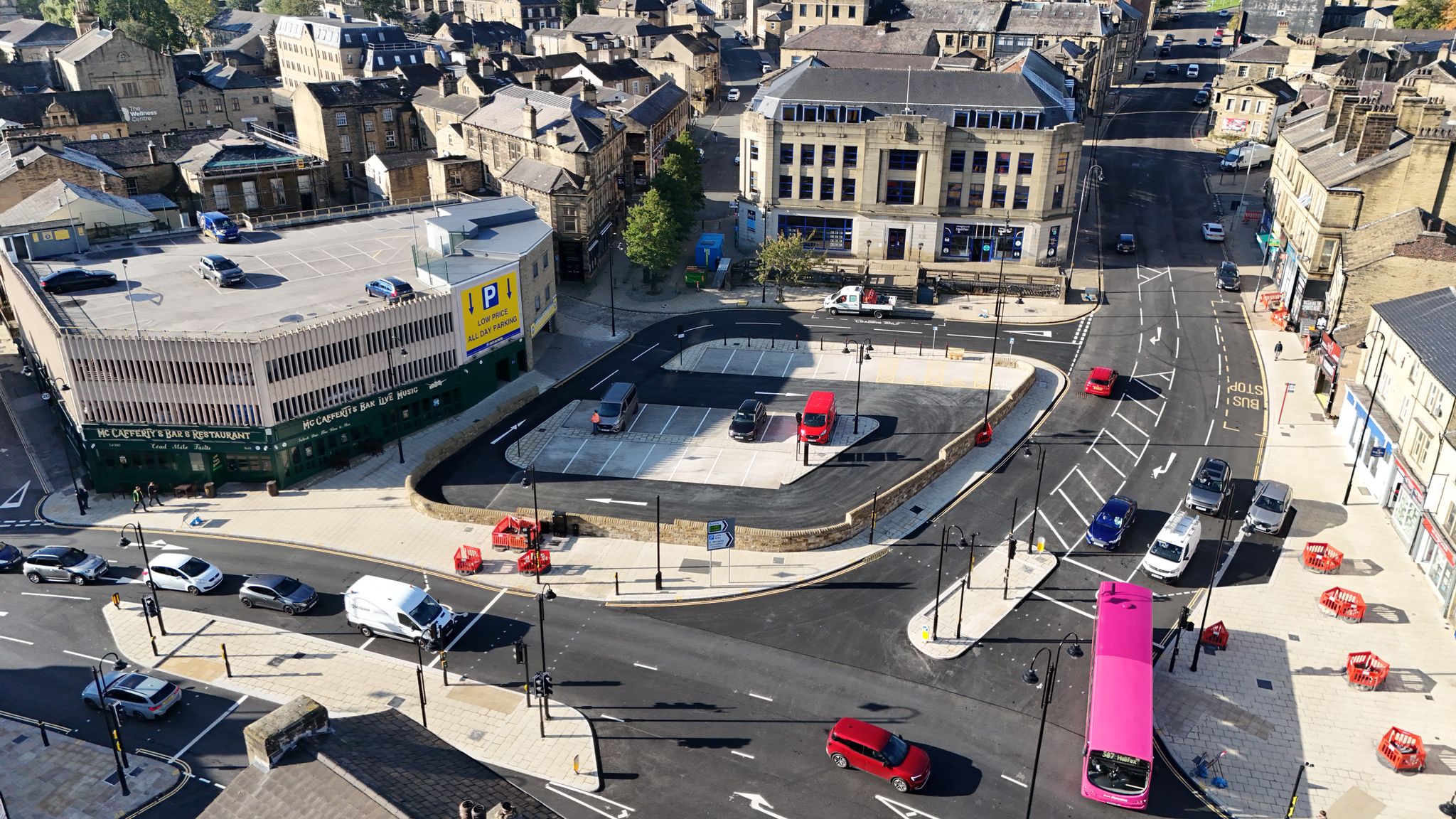 View of Bull Green from above with cars and a bus travelling through the area using the new junction layout and traffic signals. The new Bull Green car park can be seen in the background along with new and improved paving around it.